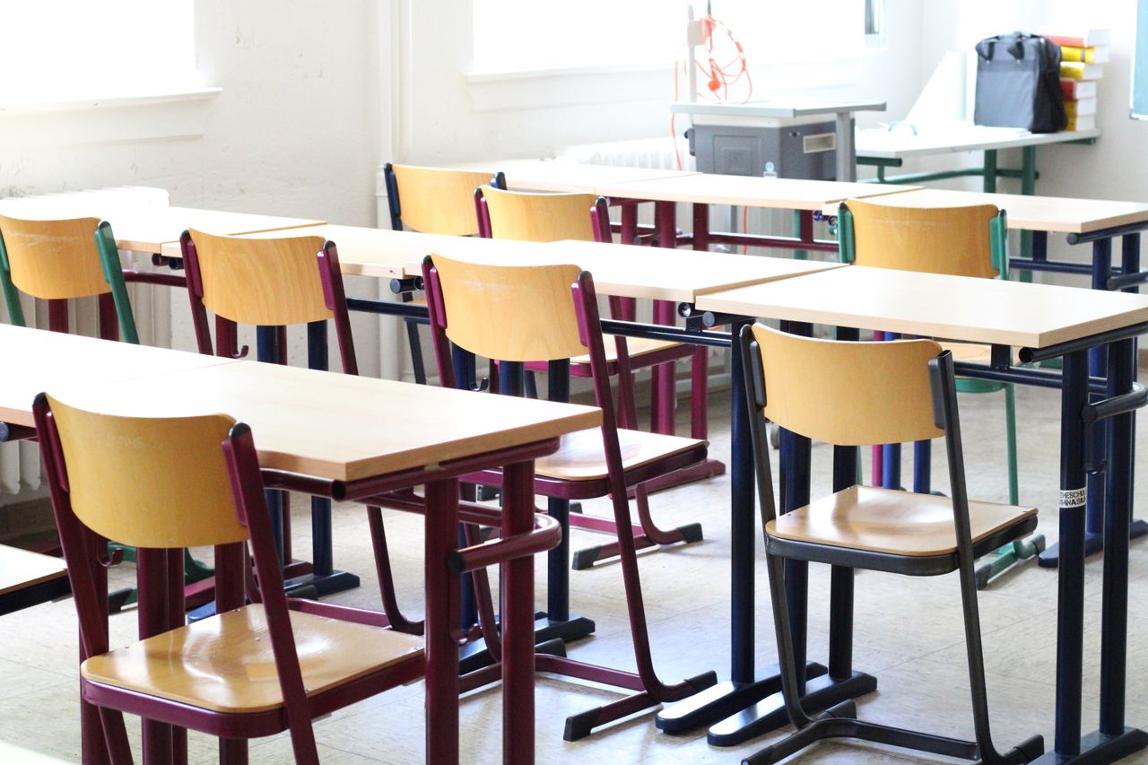 Mastering the First Impression: Your intriguing post title goes here A bright empty classroom with wooden tables and chairs, ready for students.